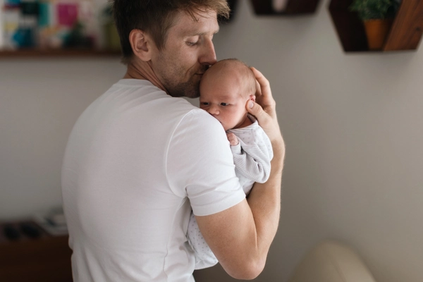 ein Vater hält sein Baby im Arm
